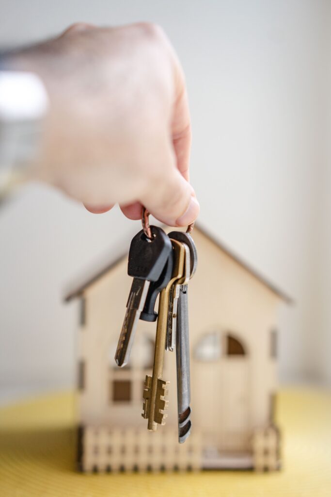 Keys in front a model house.